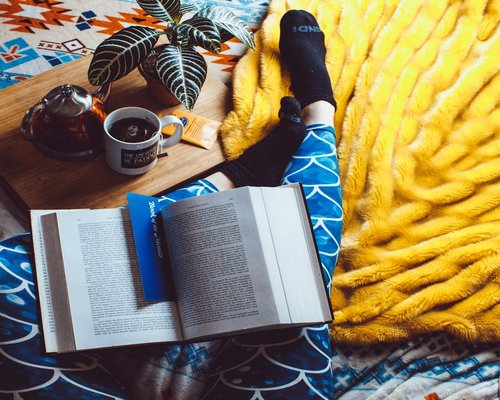 Person reading a book in a cozy room before sleeping